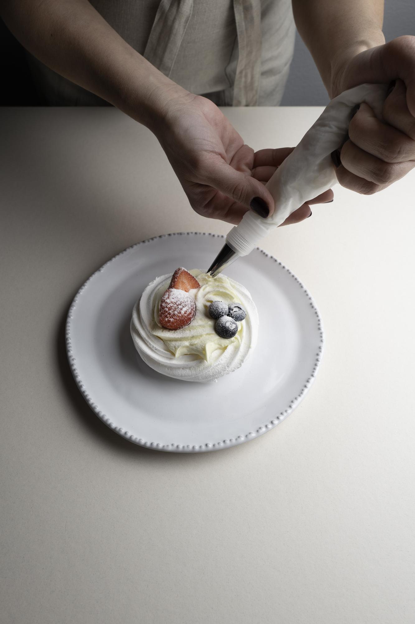 Hands arranging dessert in studio